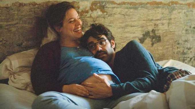 Fotogramma del film in cui i protagonisti sono sdraiati a letto sorridenti