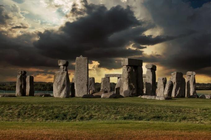 monument en pierre feito aucune période néolithique. Pedras disponible en champ vert avec nuvens noir no ceu