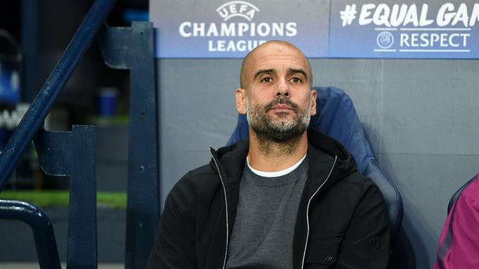 Pep Guardiola sitting on the bench